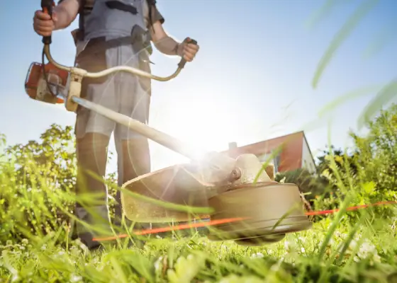 Homme tondant l'herbe avec un coupe-bordure